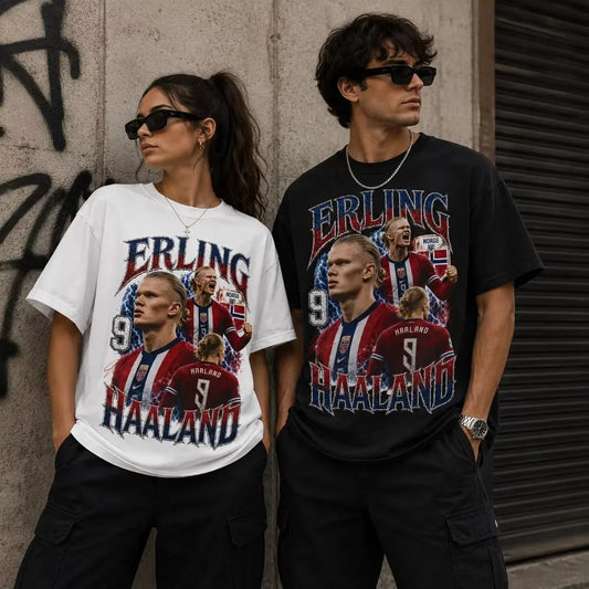 Two models wearing graphic t-shirts featuring Erling Haaland football player imagery, posed against a concrete wall with graffiti.