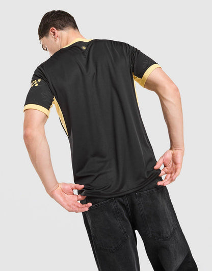 A man wearing a black short-sleeve Manchester City 2026/27 Away Jersey  with yellow trim on the collar and sleeve cuffs, shown from the back against a light gray background.
