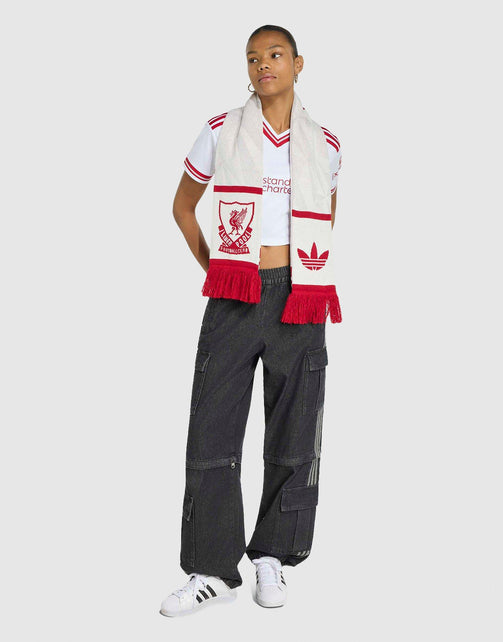 A model wearing adidas Liverpool FC 26/27 Away Jersey Crop with scarf draped over their shoulders, paired with a white crop top, dark gray cargo pants, and white sneakers, set against a solid light gray background.